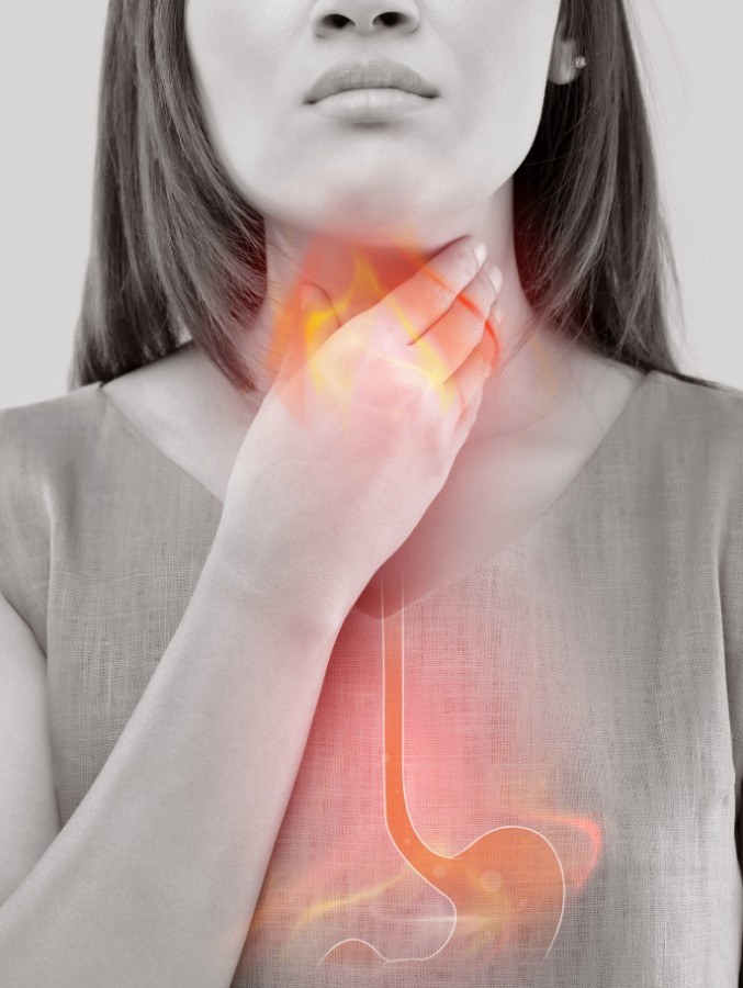 Woman with acid reflux holding her neck with animated orange lines from neck to stomach