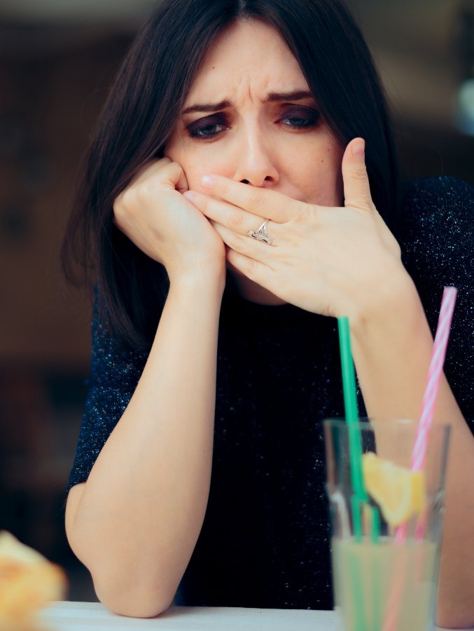Woman covering her mouth and looking worried