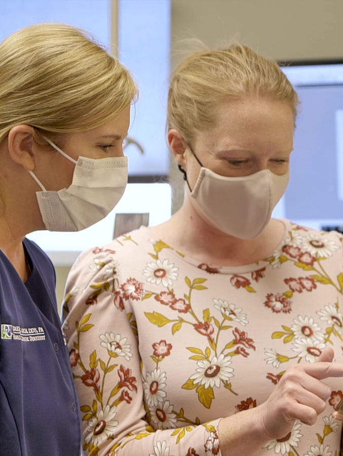 Dental team member and patient looking at cell phone together