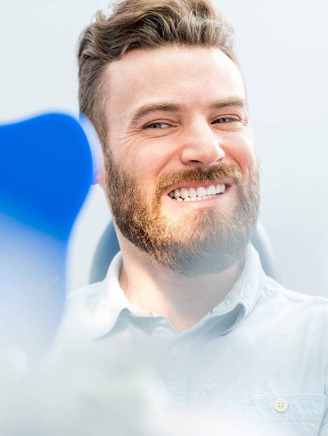 Bearded man checking his smile in a mirror