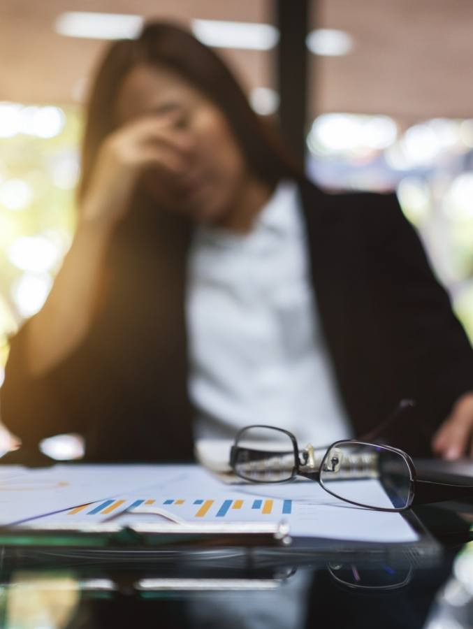 Businesswoman sighing with head in hand