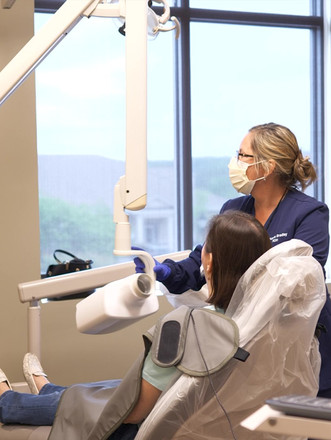 Dental team member taking dental x rays of a patient's mouth