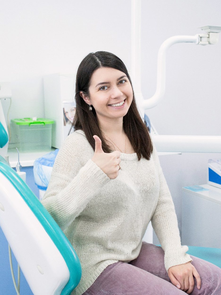 Female dental patient giving a thumbs up