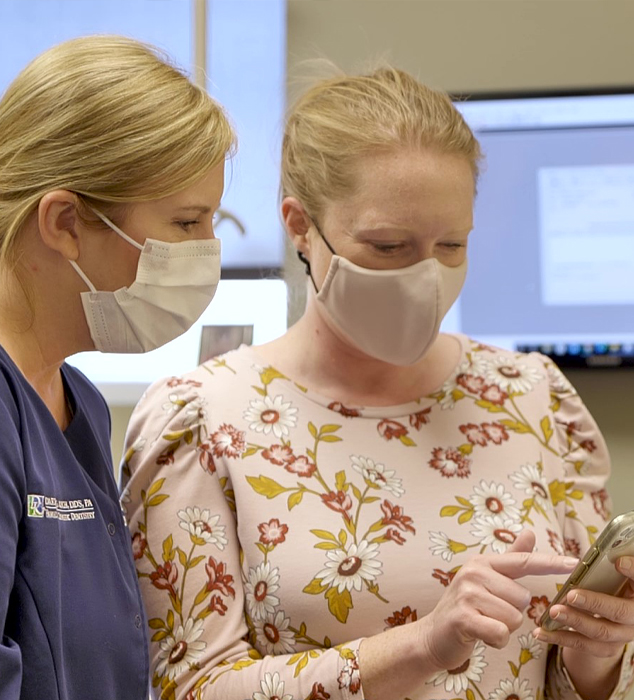 Cary dental team member and patient looking at cell phone together