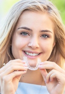 young woman holding clear aligner 
