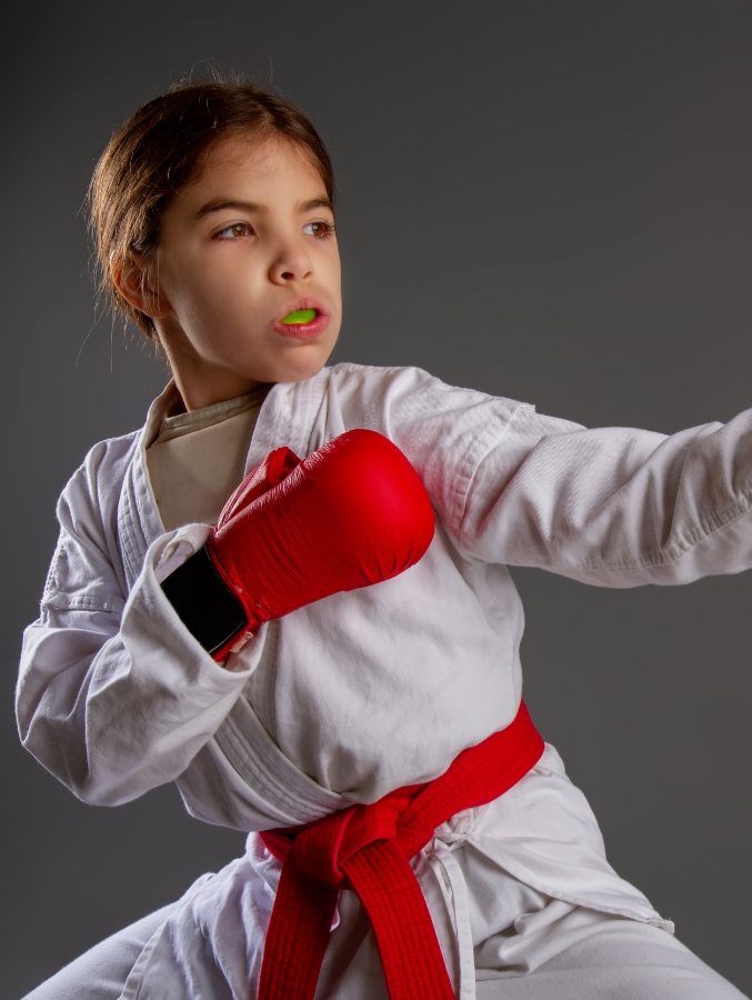 Young girl wearing karate outfit and athletic mouthguard in Cary