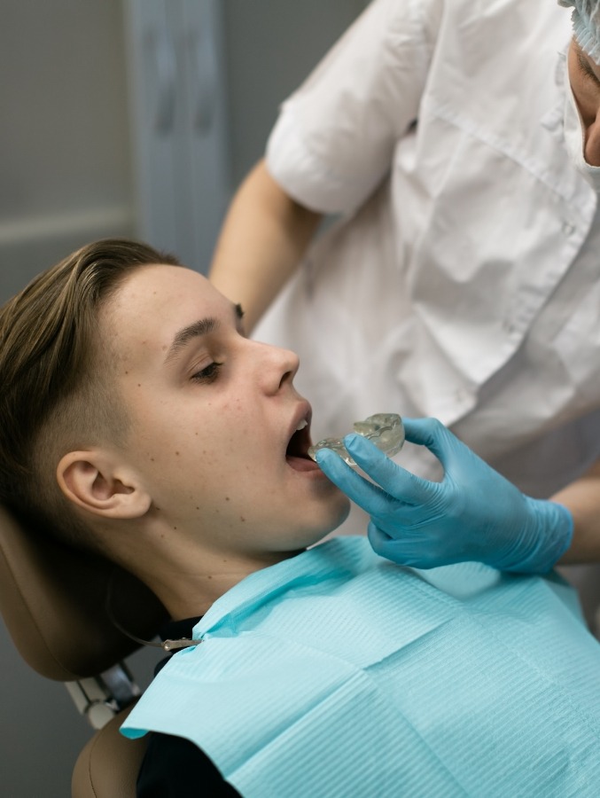 Dentist fitting patient with an athletic mouthguard
