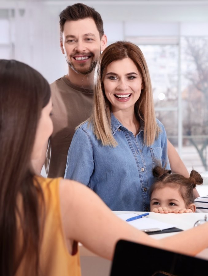 Family of three talking to dental team member