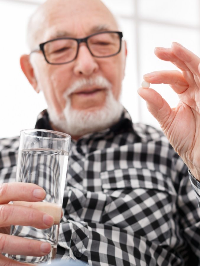 Older man about to take a pill before seeing sedation dentist in Cary