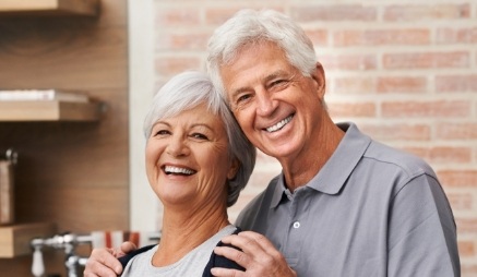 Senior man and woman smiling in their kitchen