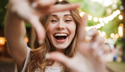 Grinning woman making a square shape with her fingers