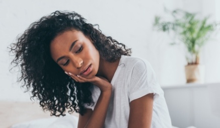 Young woman holding the side of her jaw in pain