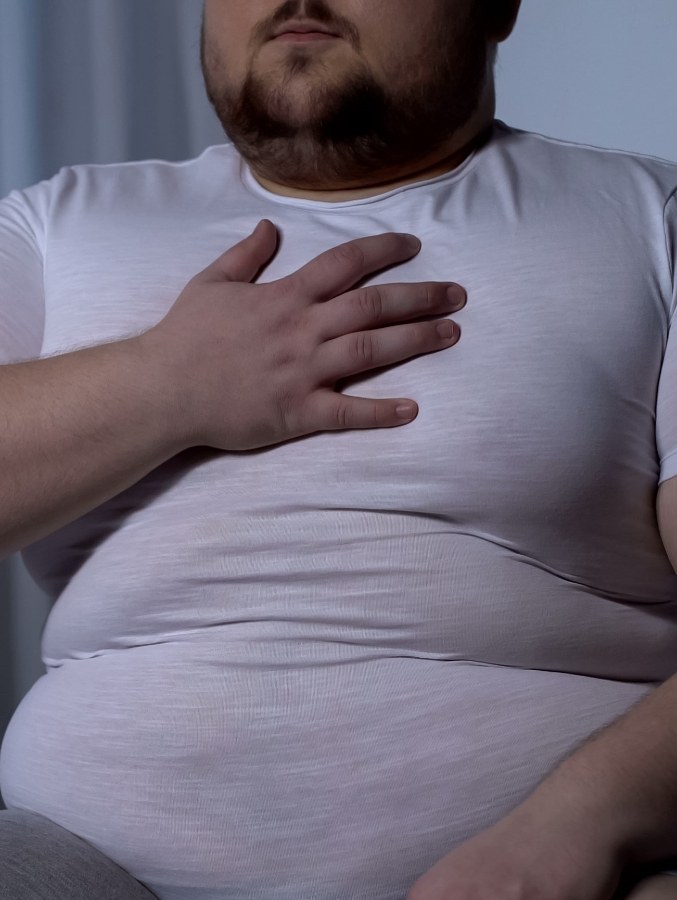 Close up of man holding his chest in pain