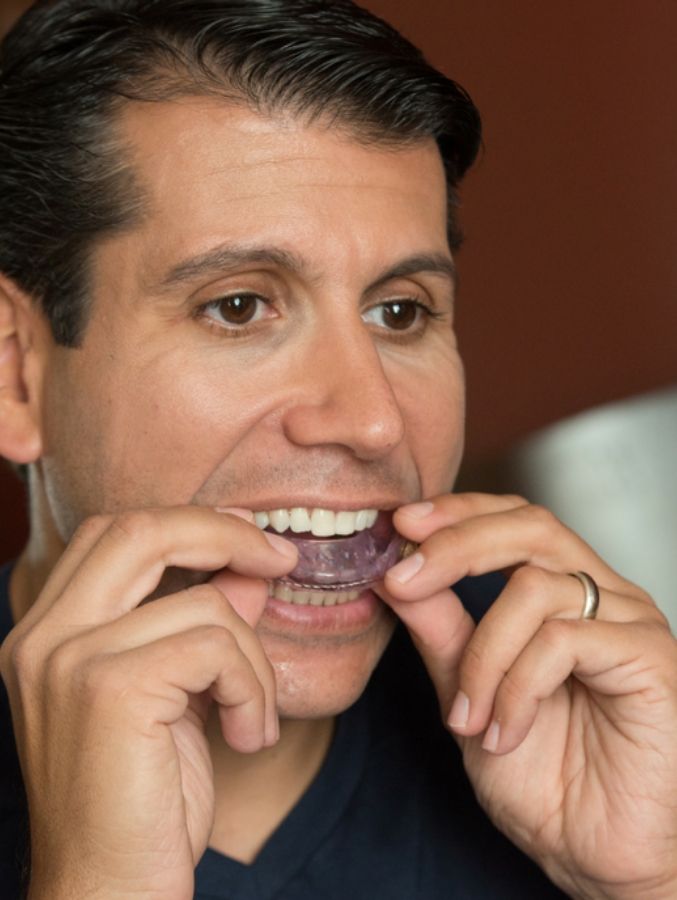 Man placing oral appliance in his mouth