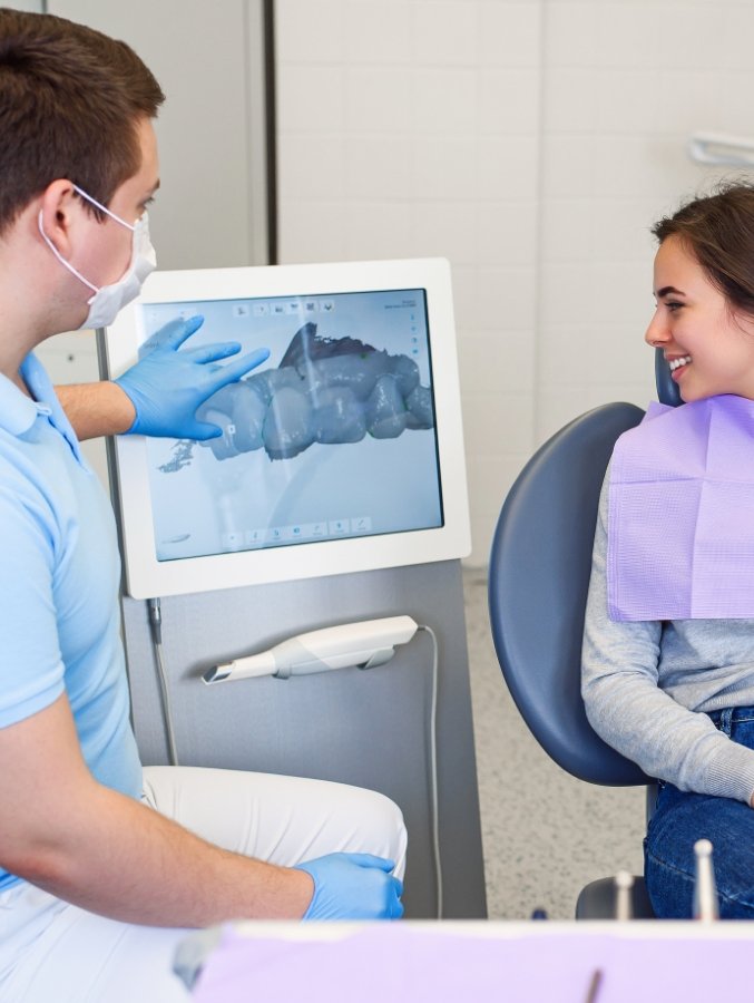 Dentist showing a patient digital impressions of their teeth on chairside monitor