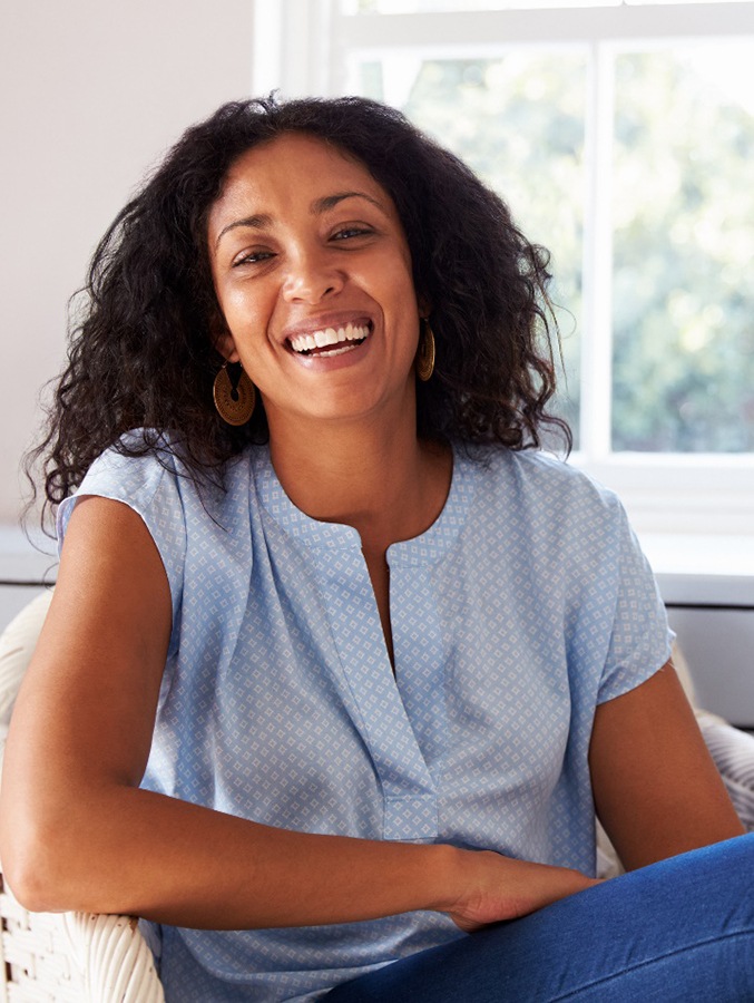 Woman in light blue shirt smiling at home