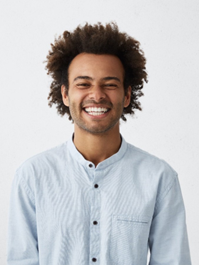 Man in button-up shirt standing and smiling