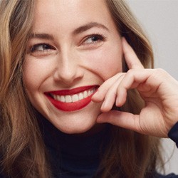 Close-up of smiling woman with red lipstick