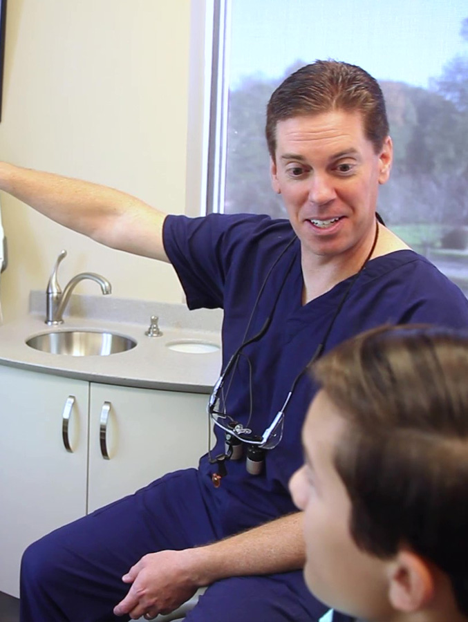 Cary dentist pointing to something out of frame while talking to dental patient