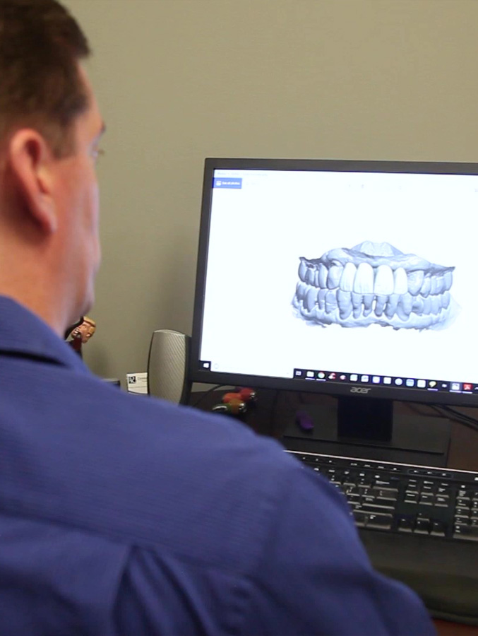 Doctor Koch looking at digital model of teeth on computer screen