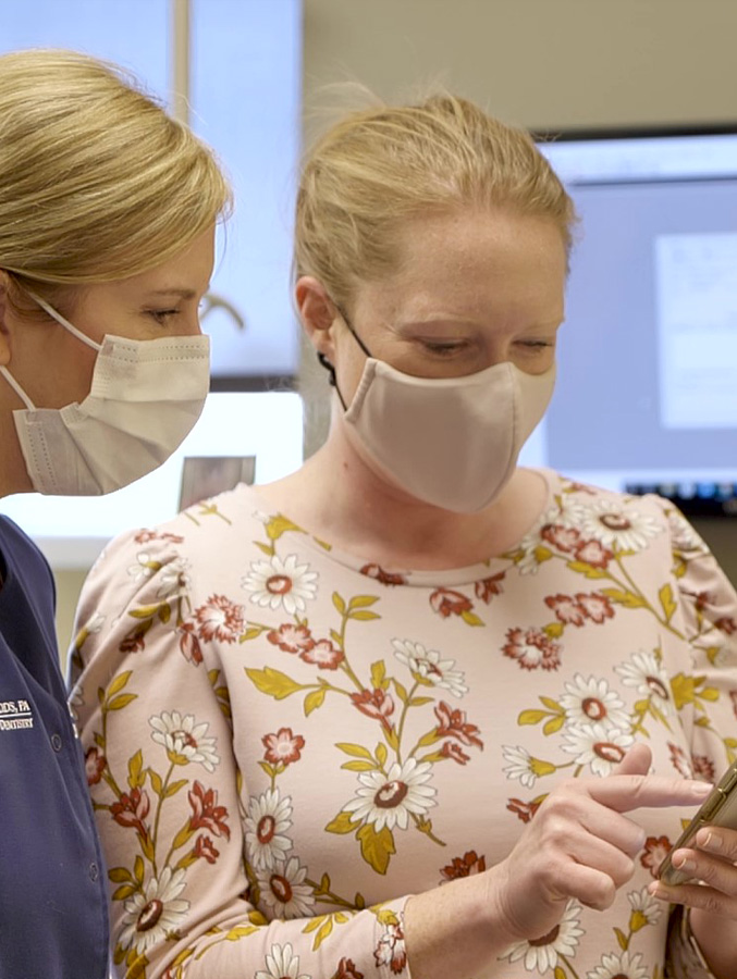 Dental team member and patient looking at cell phone together