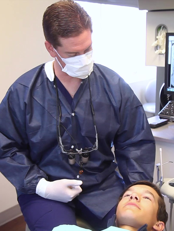 Doctor Koch talking to young man in dental chair