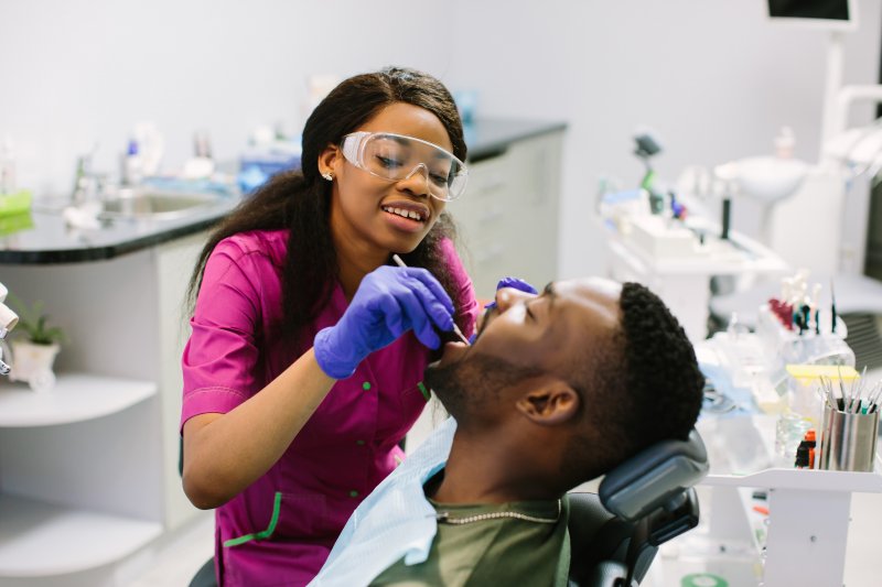 an emergency dentist performing dental work on a male patient 