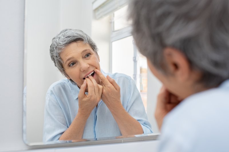 woman flossing dental implants