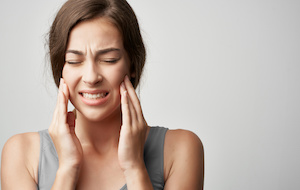 woman grimacing with a toothache