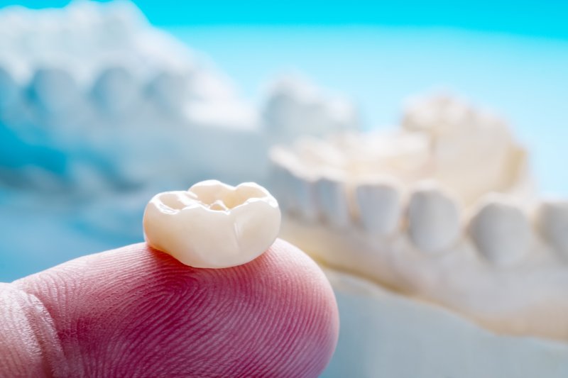 Close-up of a dental crown on a finger