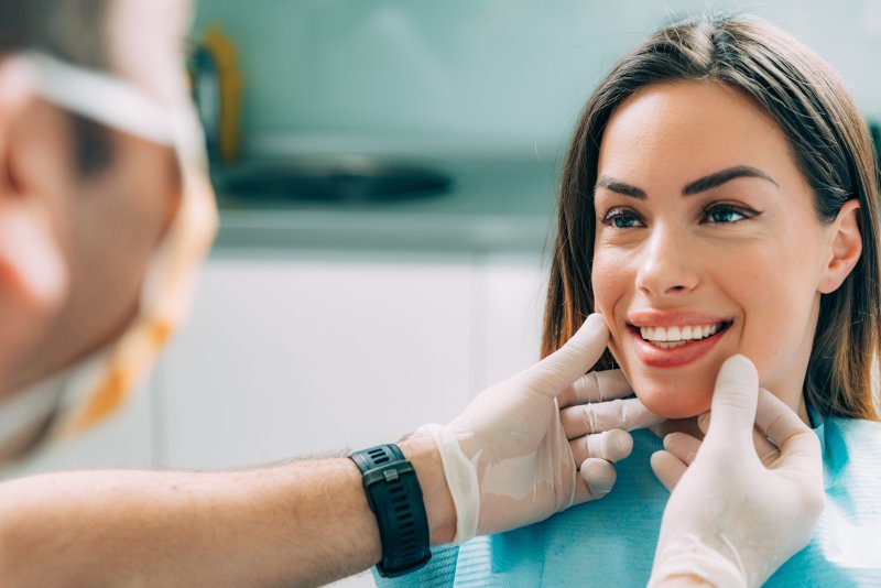 A cosmetic dentist performing treatment