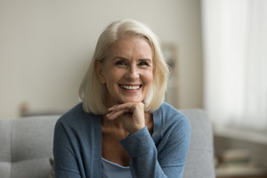 Senior woman sitting on couch and smiling