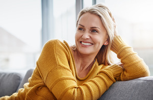 Woman in yellow shirt relaxing on a couch