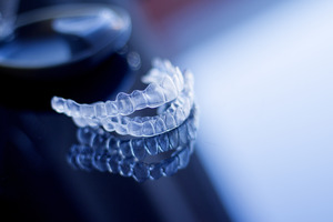 Close-up of two Invisalign aligners on reflective surface