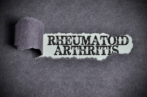 Tearing back sugar paper to reveal the words “Rheumatoid Arthritis”