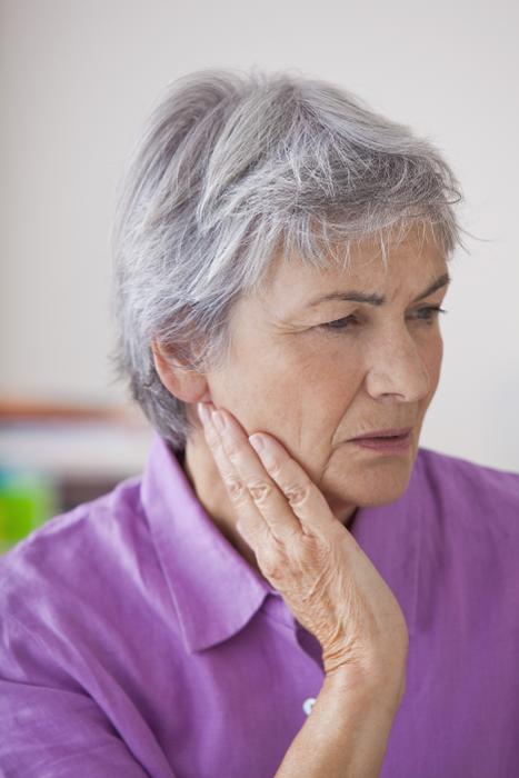woman in pain holding jaw | emergency dentist cary nc