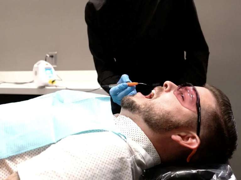 patient with dentist laying in chair | gum disease cary